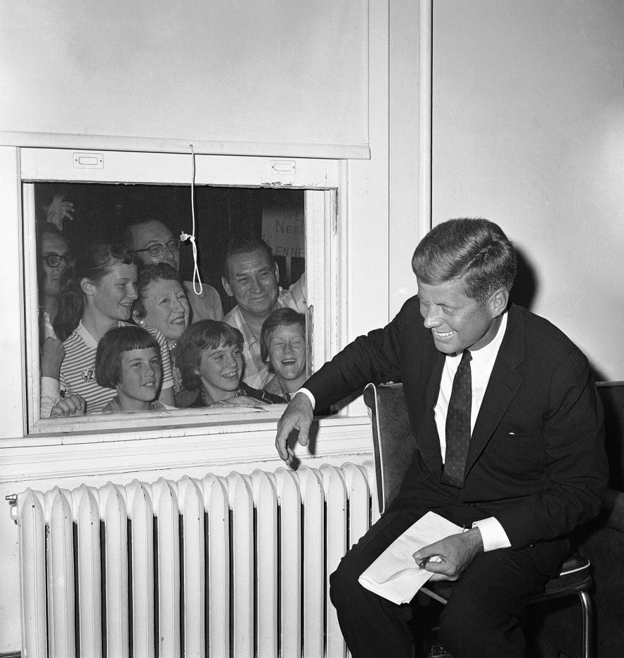 People jam the window behind Kennedy during a campaign stop in Baltimore in September 1960.
