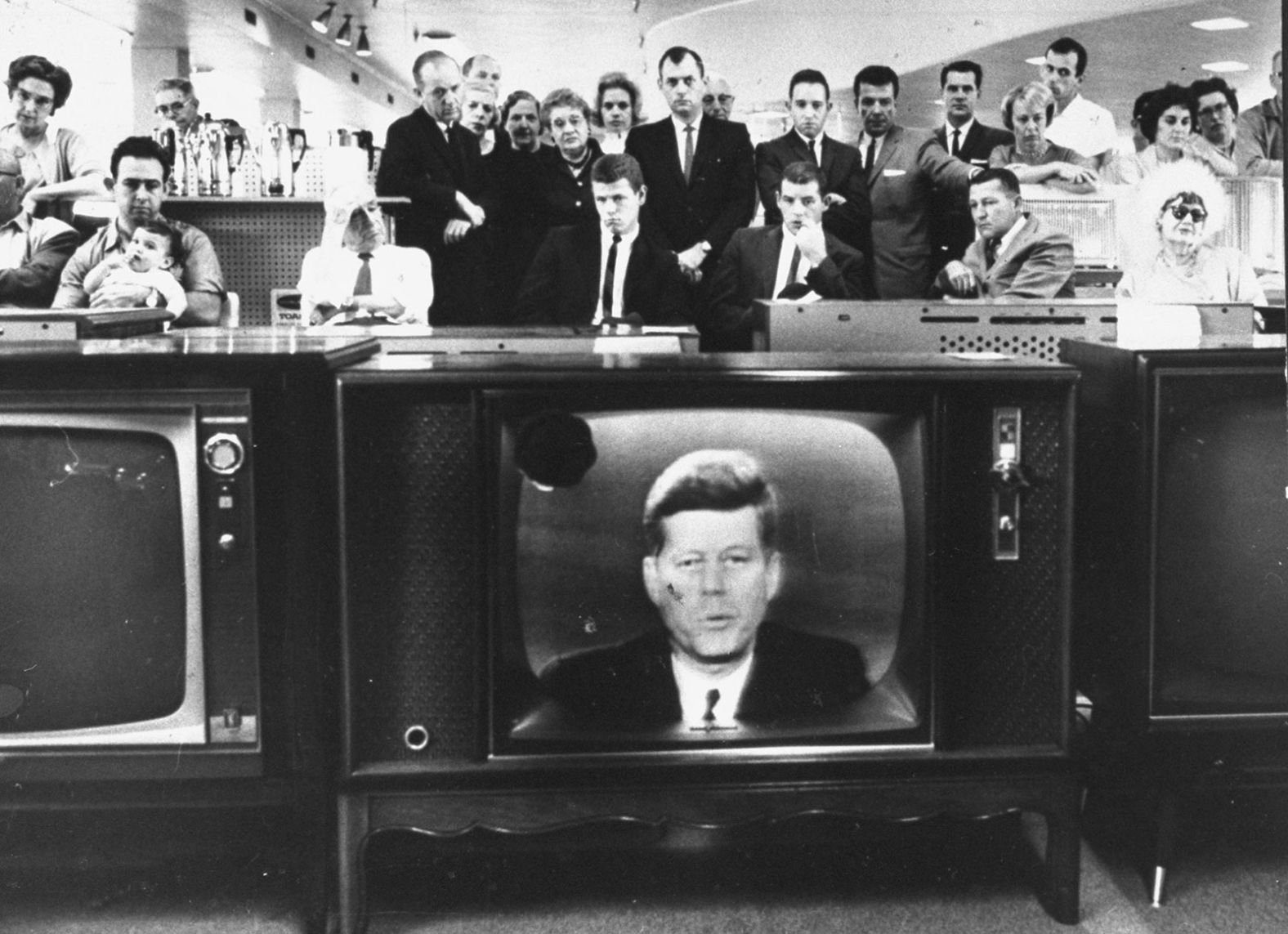 Customers in a California store's electronics department watch Kennedy deliver a televised address about the Cuban Missile Crisis in October 1962.