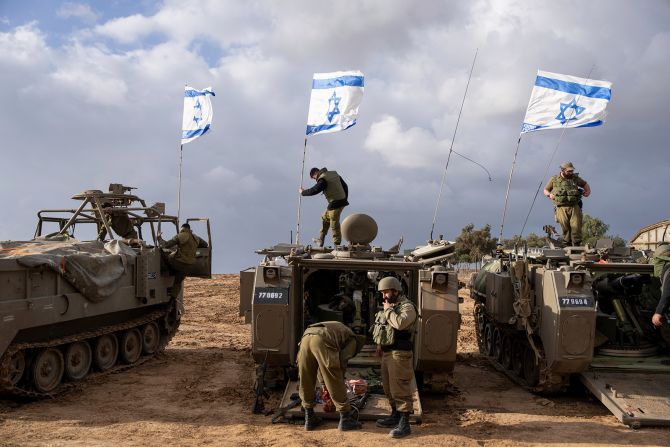 Israeli soldiers work on armored military vehicles along Israel's southern border with the Gaza Strip, on November 20.