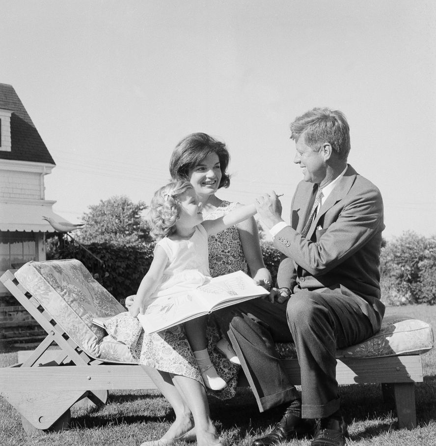 Caroline Kennedy reaches for her father while sitting on her mother's lap at their home in Hyannis Port in July 1960. 