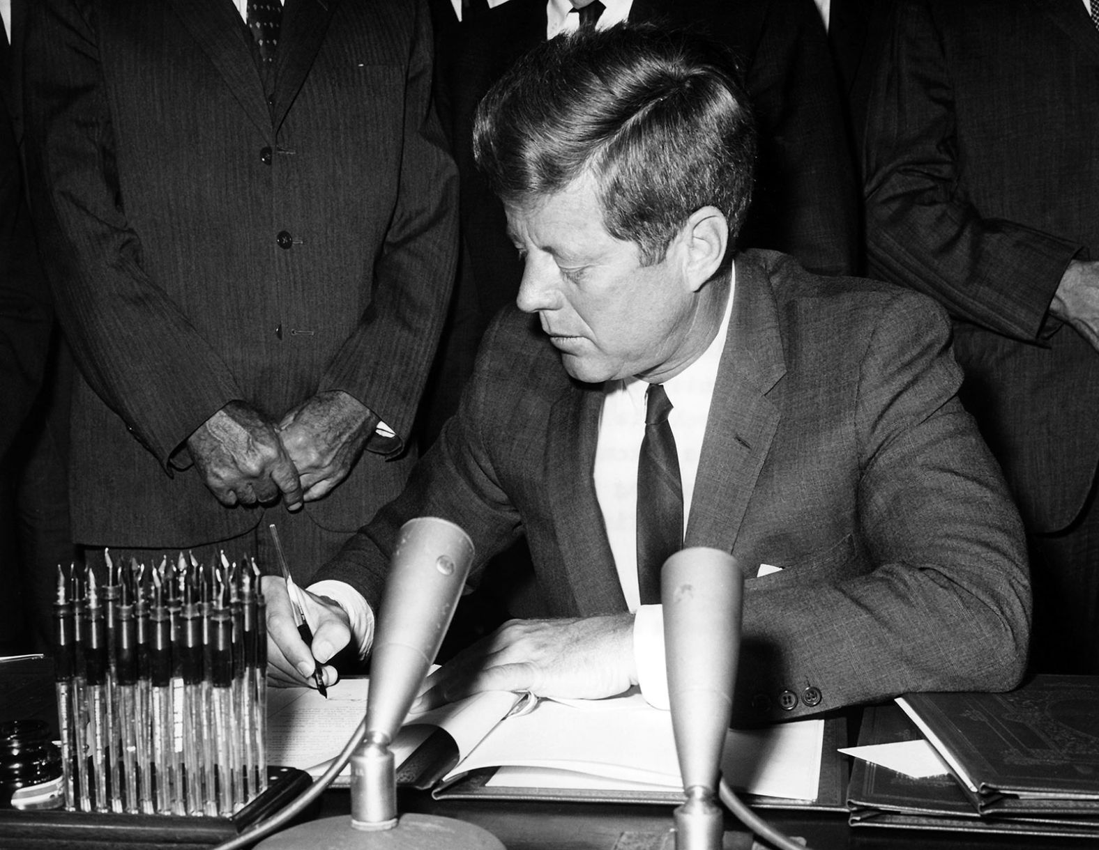 Kennedy signs the Partial Nuclear Test Ban Treaty in October 1963. The treaty, prompted by a public fear of radioactive fallout from nuclear weapons tests, banned the testing of nuclear weapons in the air, space and water. 