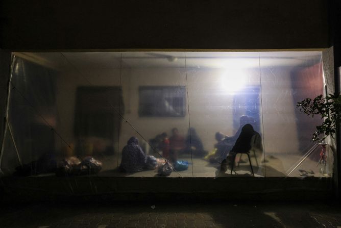 Internally displaced Palestinians who fled northern Gaza sit in a makeshift shelter at a school in Khan Younis, southern Gaza, on November 21.