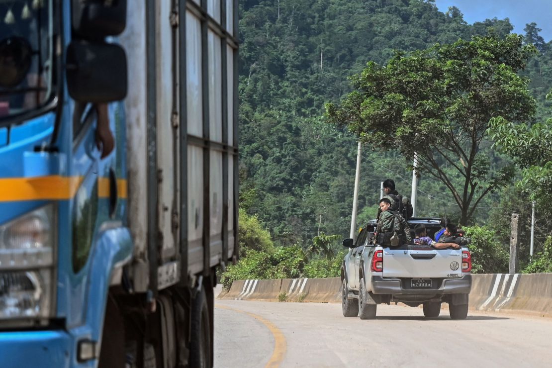 TOPSHOT - This photo taken on September 24, 2023 shows members of the Karen state Border Guard Forces (BGF) patrolling on the Yangon-Myawaddy section of the Asia Highway road near Kawkareik township. The Myadawady-Yangon section of the Asia Highway is just 400 kilometres long but snakes through rain-sodden, landslide-prone hills and its traffic obeys the rhythm of sporadic clashes between junta troops and their opponents. (Photo by AFP) / To go with 'MYANMAR-UNREST-TRANSPORT,FOCUS' (Photo by STR/AFP via Getty Images)