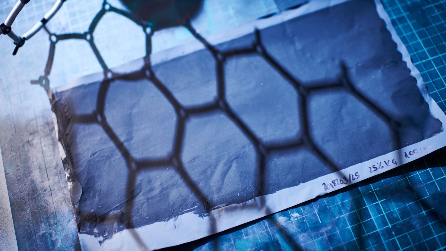 A model showing the hexagonal structure of graphene cast a shadow on graphene ink coated onto metal foil for the construction of battery & supercapacitor electrodes in a laboratory at the National Graphene Institute facility, part of the The University of Manchester, in Manchester, U.K., on Thursday, April 12, 2018. Researchers are studying ways to use graphene in batteries, and the material has the potential to significantly boost performance in a much-needed technology. Photographer: Matthew Lloyd/Bloomberg via Getty Images