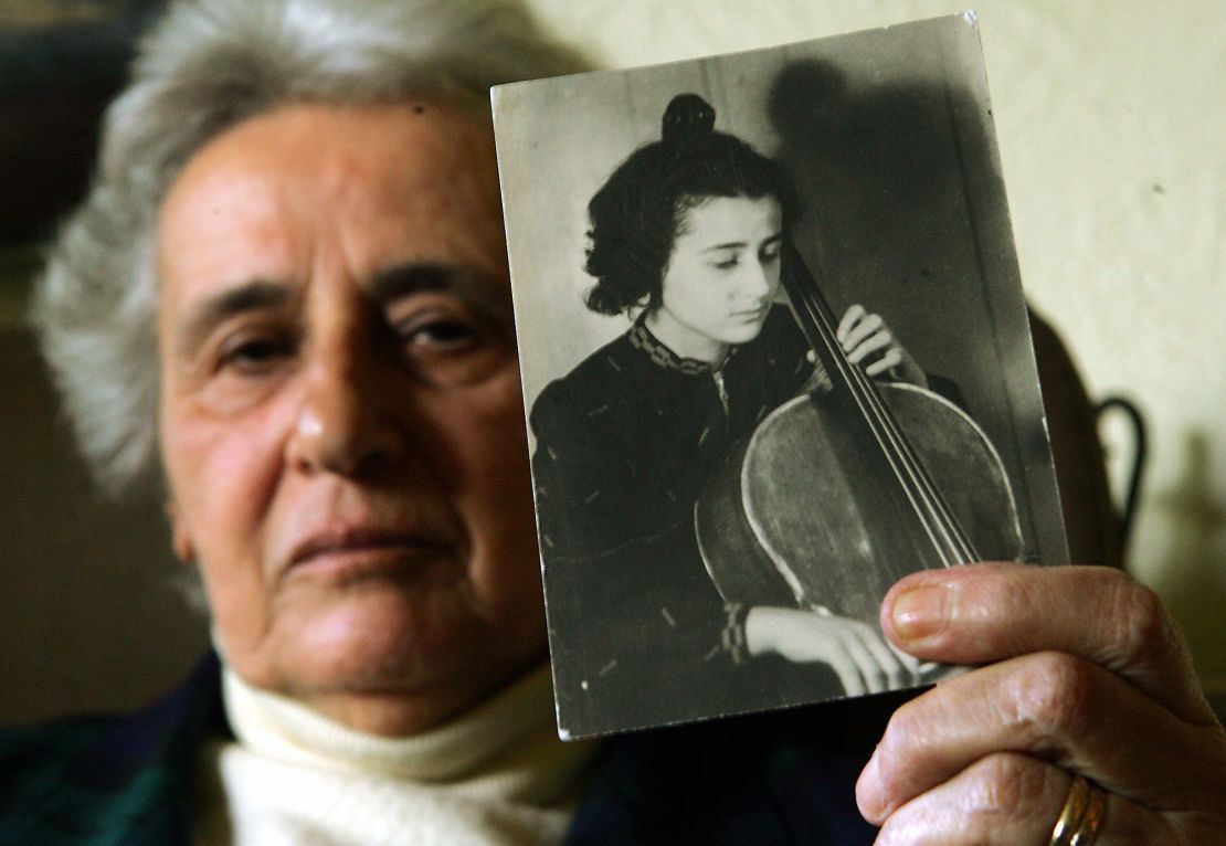 LONDON, UNITED KINGDOM:  Holocaust survivor Anita Lasuer holds up a portrait of herself playing the cello taken in Berlin before WWII during an interview before the 60th anniversary of the liberation of Auschwitz 18 January 2005 in London. Lasuer survived Aucshwitz, in part, because she is a tallented cellist and playing in the camp orchestra.     AFP PHOTO/JIM WATSON  (Photo credit should read JIM WATSON/AFP via Getty Images)