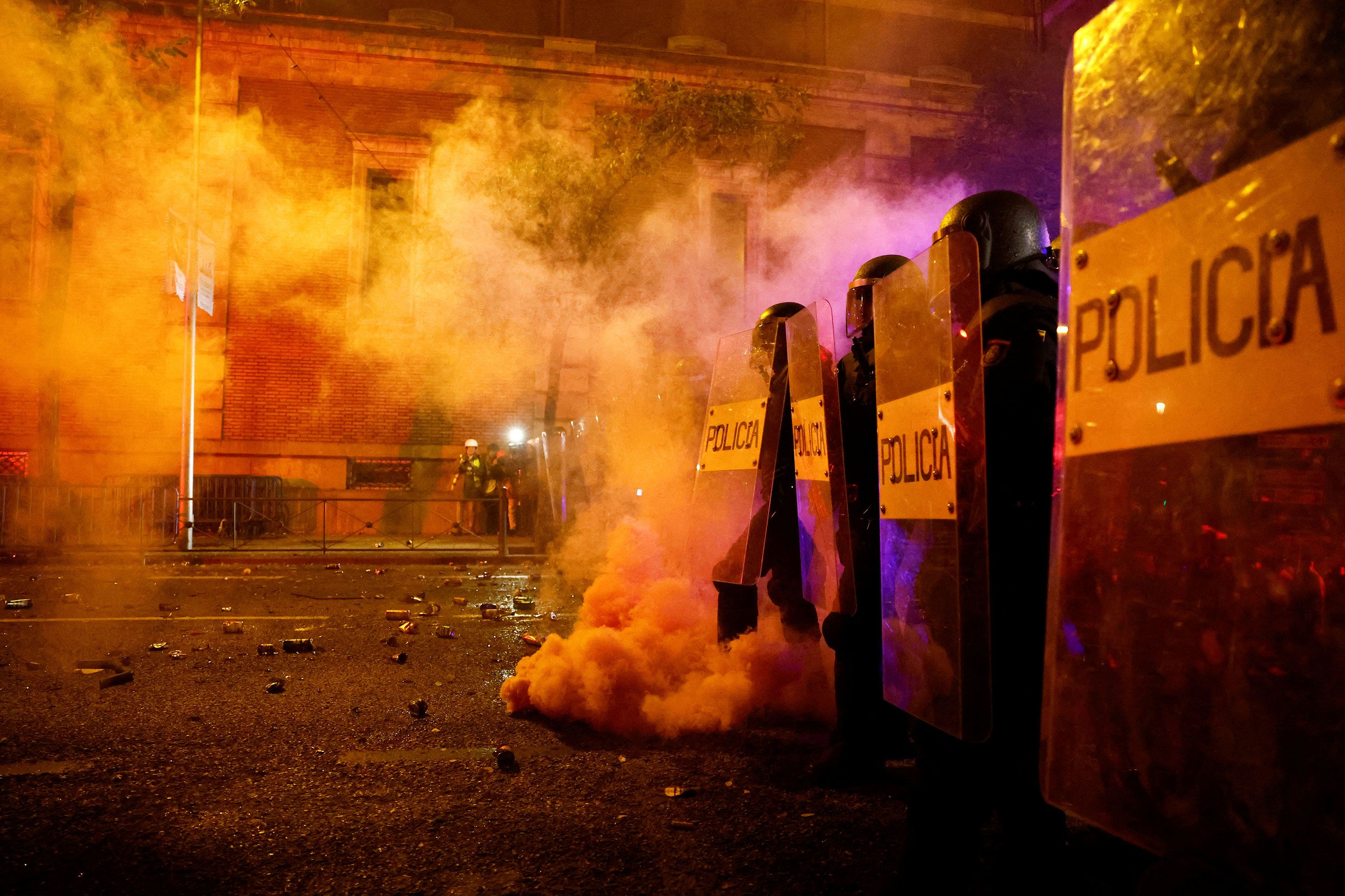 Police stand behind shields during a protest in Madrid on Thursday, November 16.