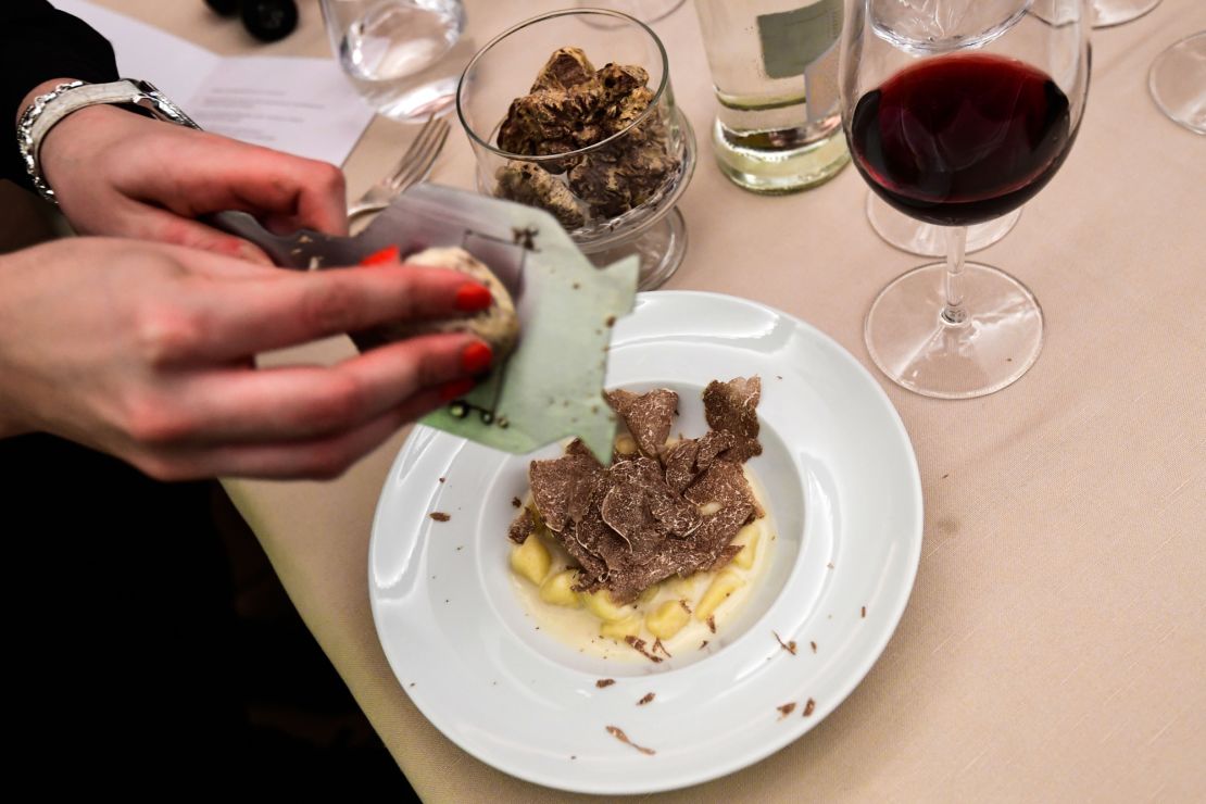 A waitress grates white Alba truffle over a plate of potato gnocchetti with Castelmagno melted cheese (fondue) on November 10, 2019 at a restaurant in Roddi, near Alba, within the 20th World White Truffle auction in Alba, northern Italy. - Every year for 89 years, the city of Alba hosts for nearly two months a large white truffles fair during which the auction takes place. (Photo by Miguel MEDINA / AFP) (Photo by MIGUEL MEDINA/AFP via Getty Images)