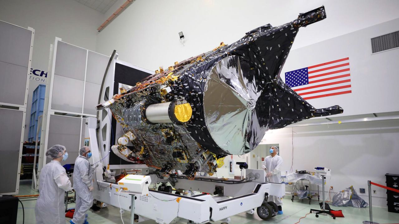 NASA's Psyche spacecraft is shown in a clean room at the Astrotech Space Operations facility near the agency's Kennedy Space Center in Florida on December 8, 2022. DSOC's gold-capped flight laser transceiver can be seen, near center, attached to the spacecraft.