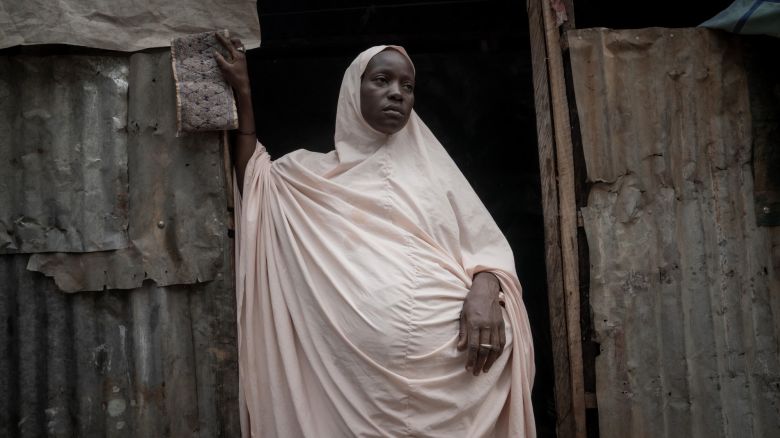 Aisha who is expecting her 10th child stands in front of her home at the Durumi IDP camp, Abuja