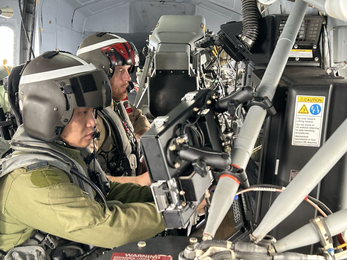 Radar operators scan their instruments in a Canadian antisubmarine warfare helicopter over the East China Sea.