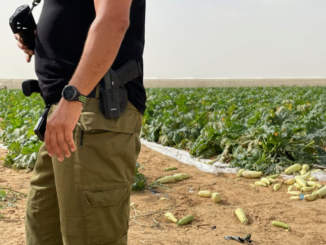 Since the October 7 attacks, farmer Yosi Inbar patrols his fields with his rifle to protect his staff and volunteers.