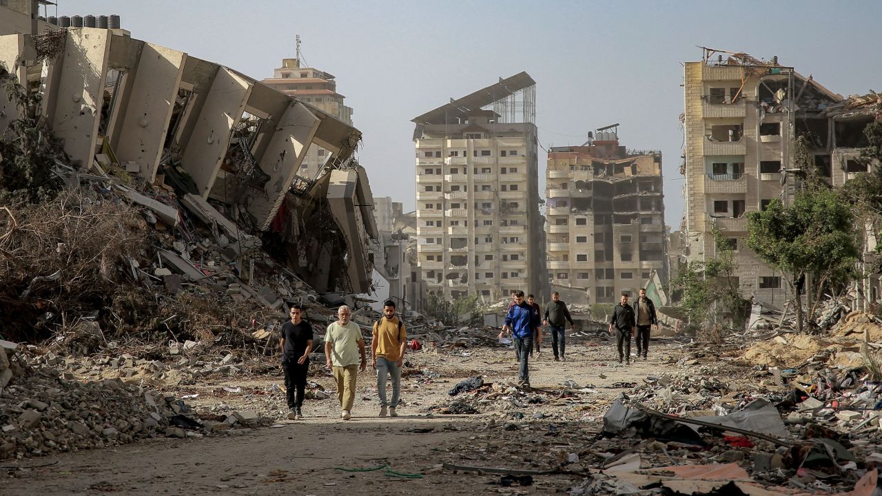 Palestinians walk amidst the rubble of destroyed buildings in Gaza City on November 26, 2023, on the third day of a truce between Israel and Hamas.