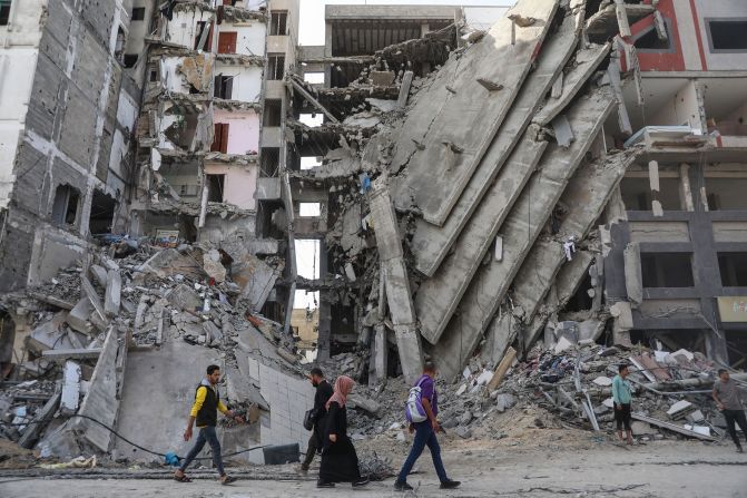 Palestinians walk through destruction in Gaza City on November 24 as a temporary truce between Israel and Hamas took effect.