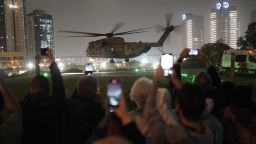 A group of Israelis watch as a helicopter carrying hostages released from the Gaza Strip lands at the helipad of the Schneider Children's Medical Center in Petah Tikva, Israel, Sunday Nov. 26, 2023. The cease-fire between Israel and Hamas was back on track Sunday as the militants freed 17 more hostages, including 14 Israelis and the first American, in exchange for 39 Palestinian prisoners in a third set of releases under a four-day truce. (AP Photo/Leo Correa)