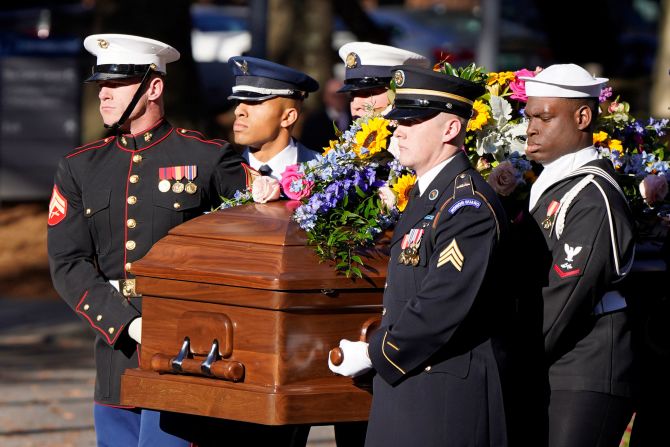A military team carries Carter's casket after it arrived in Atlanta on Monday.