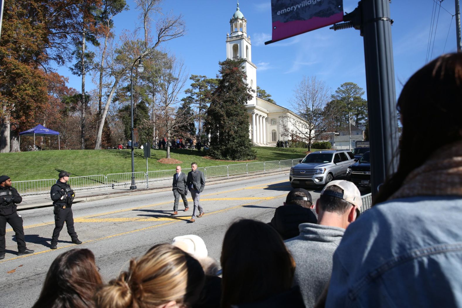 Security officials walk by as people in Atlanta await the arrival of Rosalynn's motorcade on Tuesday.