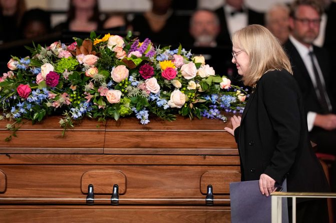 The Carters' daughter, Amy, touches her mother's casket after speaking during Tuesday's tribute service. <a href="index.php?page=&url=https%3A%2F%2Fwww.cnn.com%2Fus%2Flive-news%2Frosalynn-carter-tribute-service-tuesday-11-28-23%2Fh_33e87ca65050653aa16d7ae9549680c6" target="_blank">Amy read an old love letter</a> that her father had once written to her mother.
