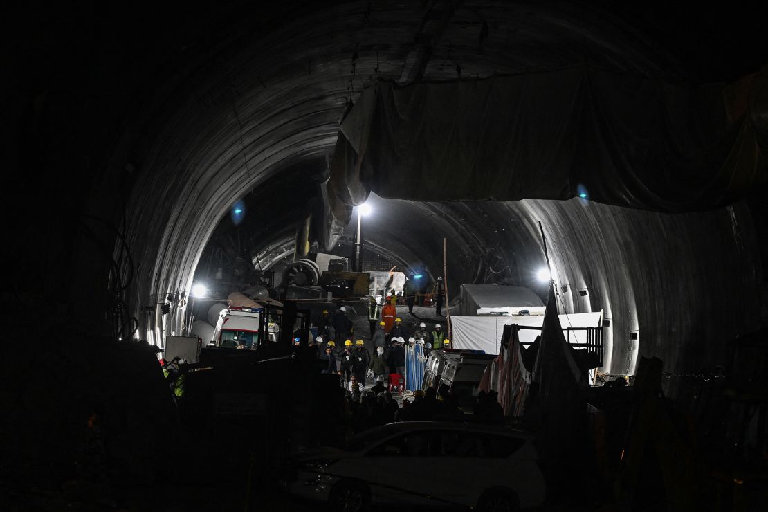 Rettungskräfte und Beamte versammeln sich am Eingang des Silkyara-Tunnels während einer Rettungsaktion, nachdem am 28. November 2023 im Bezirk Uttarkashi in Uttarakhand, Indien, ein Abschnitt des Tunnels eingestürzt ist.  Indische Rettungsteams graben von Hand.  Das Ende einer 17-tägigen Marathon-Operation zur Rettung von 41 in einem eingestürzten Straßentunnel eingeschlossenen Menschen sei in Sicht, sagten Beamte am Dienstag.  (Foto von Sajjad Hussain/AFP) (Foto von Sajjad Hussain/AFP über Getty Images)