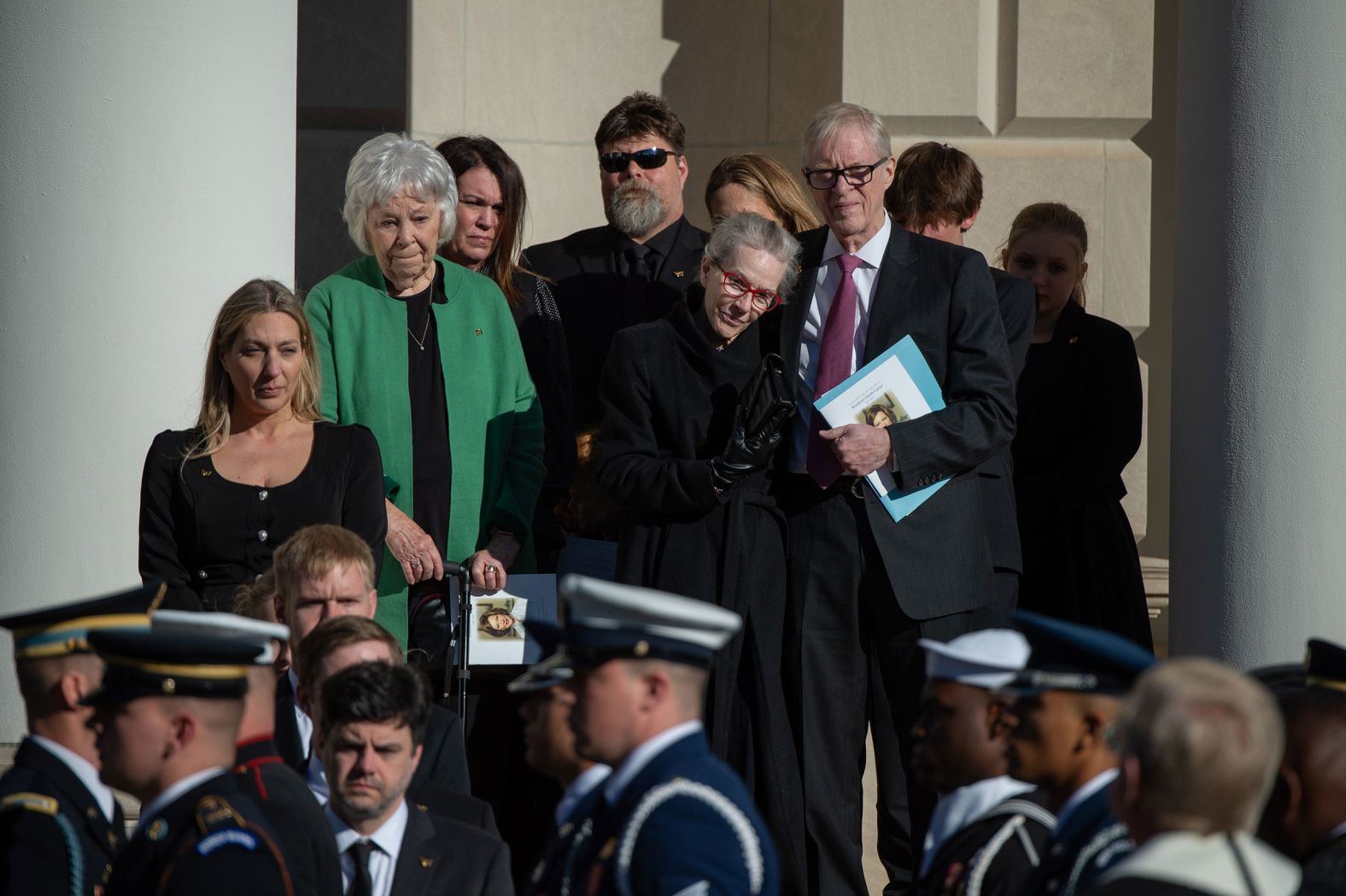 Family and friends of the Carters, including their son Jack, right, watch as Rosalynn's casket leaves the church in Atlanta on Tuesday.