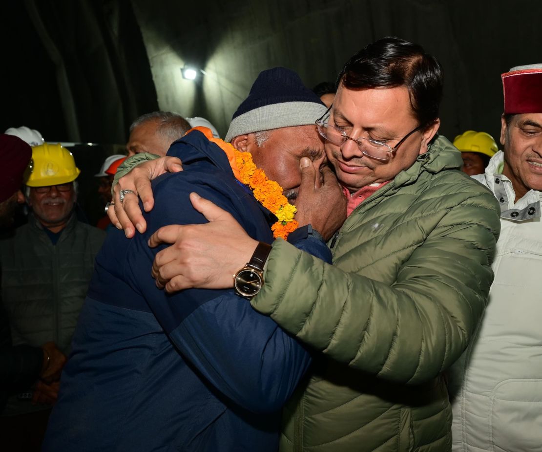 Uttarakhand's Chief Minister Rushkar Singh Dhami embraces one of the rescued laborers.