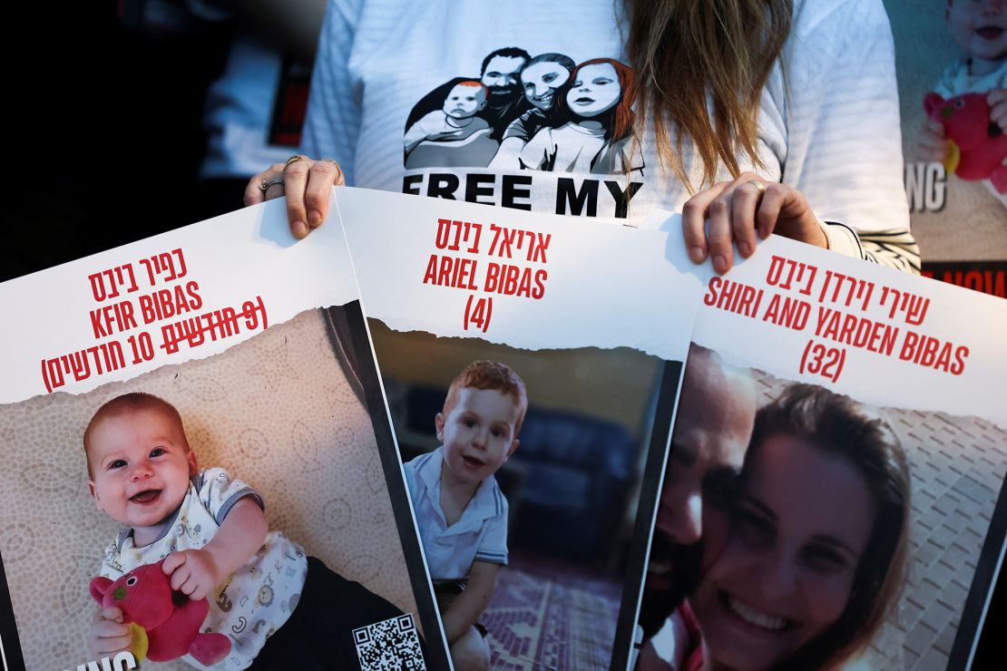 A protester holds signs calling for the release of hostages of Shiri Bibas, 32, and her children Kfir Bibas, 10 months, and Ariel, 4, during a protest calling for the immediate release of hostages, especially Shiri, her husband Yarden Bibas, 34 and their children Kfir and Ariel, during the hostages-prisoners swap deal between Hamas and Israel, in Tel Aviv, Israel, November 28, 2023. REUTERS/Athit Perawongmetha