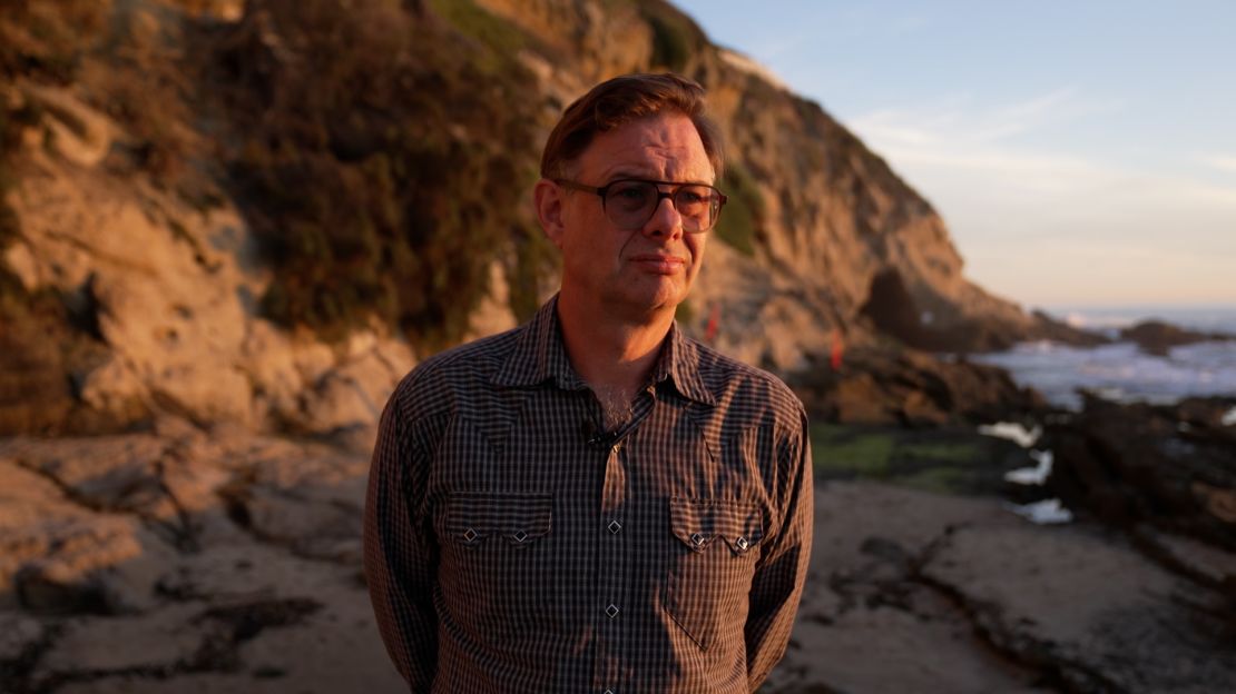 Kevin Cooley looks off into the sunset at Thousand Steps Beach in California, assessing the lighting for his evening photography session of the ocean.