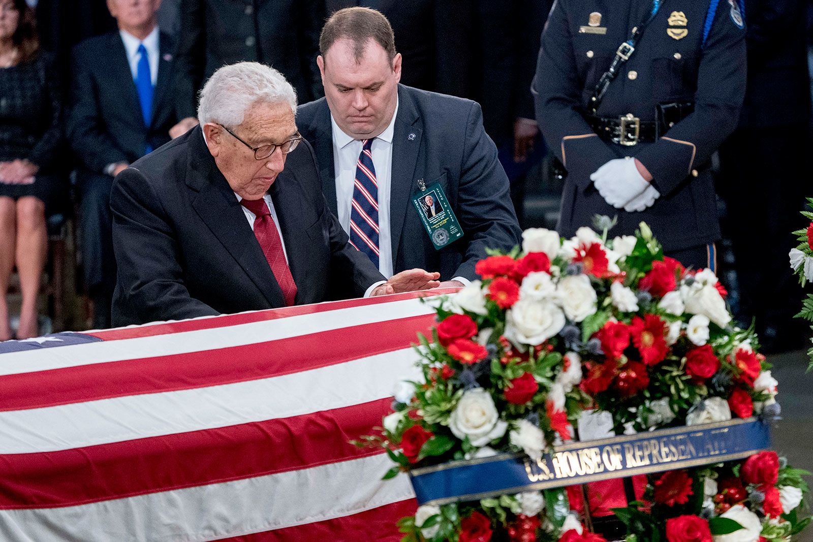 Kissinger touches McCain's casket as he lies in state at the US Capitol in 2018.