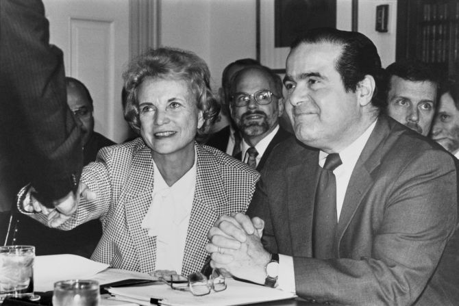 O'Connor, sitting next to fellow Supreme Court Justice Antonin Scalia, shakes hands with US Sen. Warren Bruce Rudman before a subcommittee meeting in 1992.