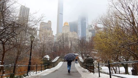 NEW YORK, NY - FEBRUARY 28: A person crosses the Gapstow Bridge in Central Park in front of buildings along Central Park South after a snowfall on February 28, 2023, in New York City.  (Photo by Gary Hershorn/Getty Images)