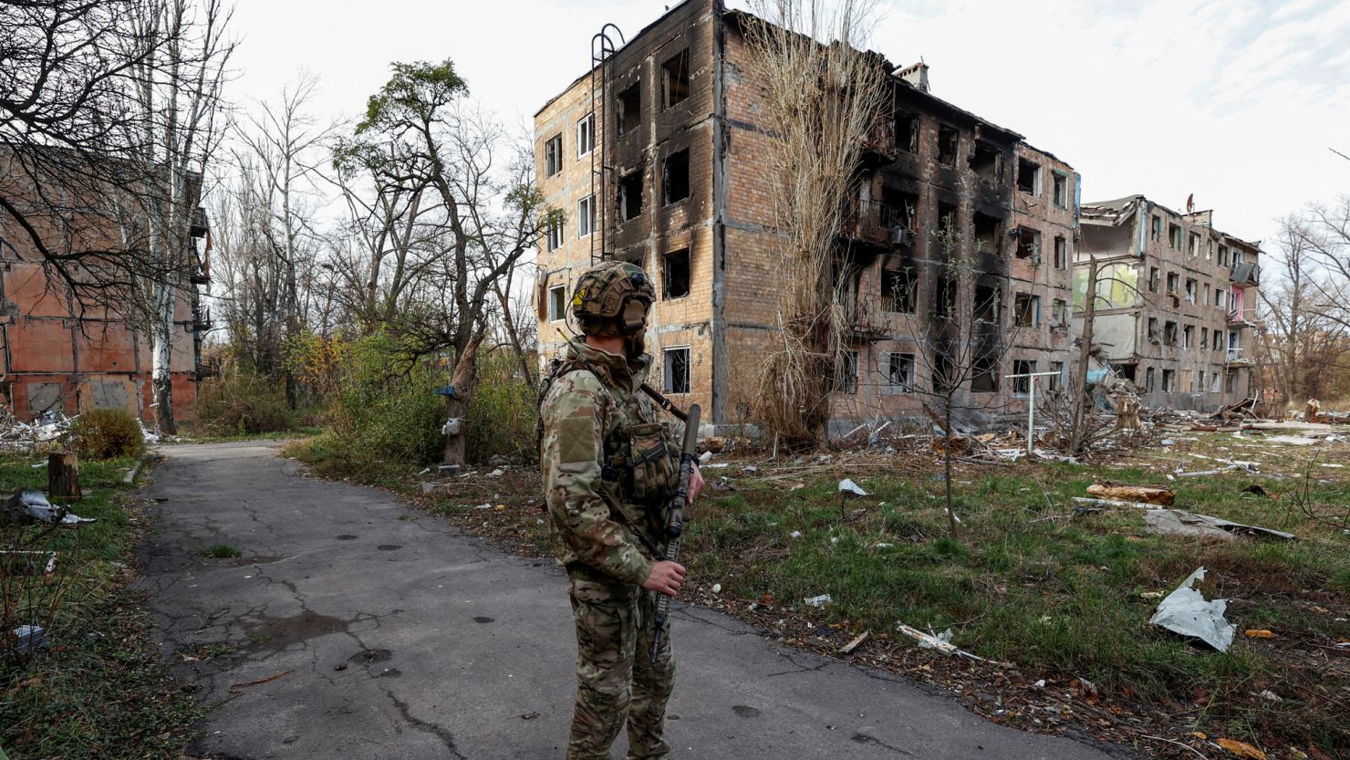 A Ukrainian serviceman stands next to residential buildings heavily damaged by permanent Russian military strikes in the front line town of Avdiivka, amid Russia's attack on Ukraine, in Donetsk region, Ukraine November 8, 2023. Radio Free Europe/Radio Liberty/Serhii Nuzhnenko via REUTERS