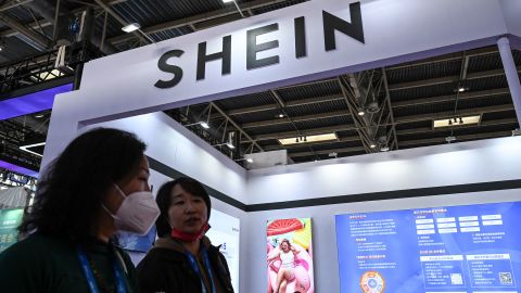 People walk past the booth of fast fashion e-commerce company SHEIN during the China International Supply Chain Expo (CISCE) in Beijing on December 1, 2023. (Photo by JADE GAO / AFP) (Photo by JADE GAO/AFP via Getty Images)