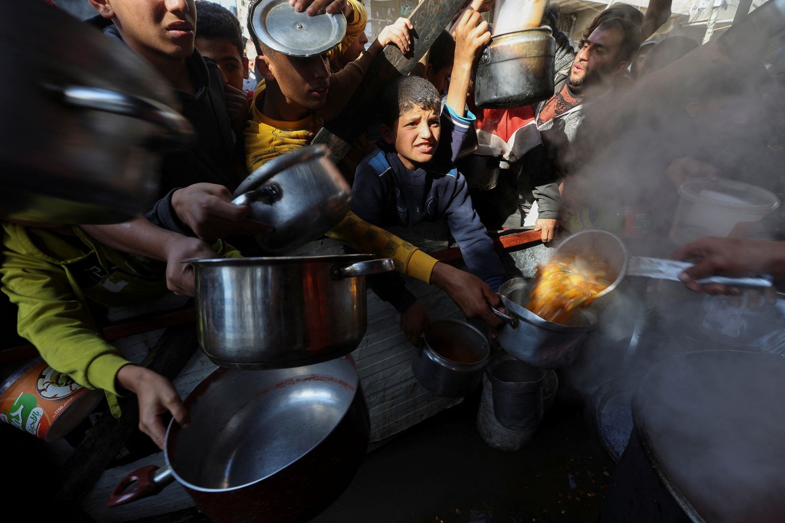 Palestinians hold empty containers to receive food in Rafah, Gaza, on December 2.