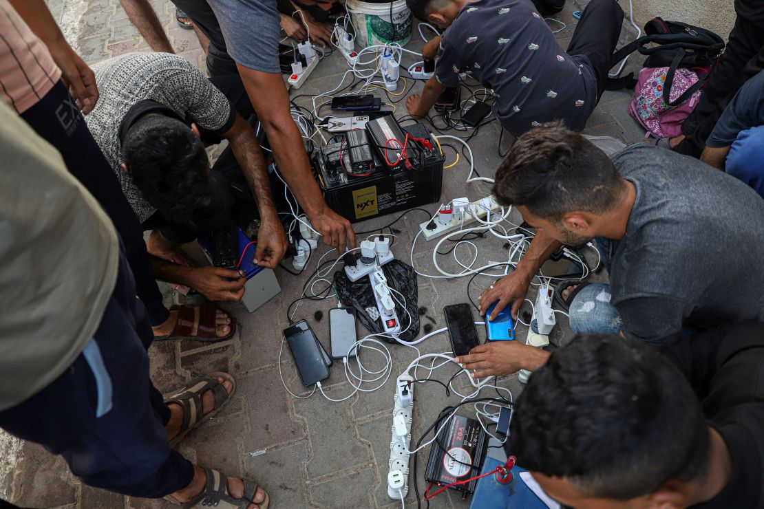 People charge their mobile phones in the southern Gazan city of Khan Younis, on Oct. 25, 2023.