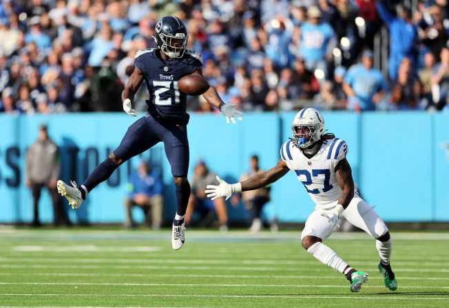 Roger McCreary of the Tennessee Titans and Indianapolis Colts running back Trey Sermon attempt to catch the ball on December 3. The Colts beat the Titans 31-28 in overtime.