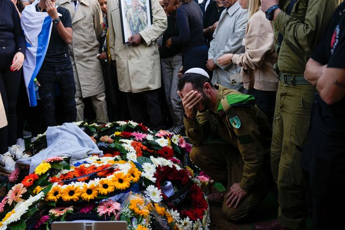 Family and friends of Staff Sergeant Aschalwu Sama mourn over his grave during his funeral in Petah Tikva, Israel, on December 3.