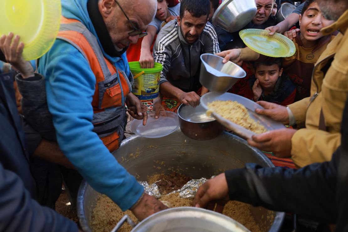 Palestinos desplazados hacen cola para recibir donaciones de alimentos en la ciudad de Rafah, en el sur de la Franja de Gaza, el 30 de noviembre de 2023. Las partes en conflicto acordaron una extensión de la pausa en los combates para dar tiempo a Hamás para liberar a más rehenes israelíes a cambio de prisioneros palestinos. (Foto de MOHAMMED ABED/AFP) (Foto de MOHAMMED ABED/AFP vía Getty Images)