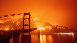 A boat motors by as the Bidwell Bar Bridge is surrounded by fire in Lake Oroville during the Bear fire in Oroville, California on September 9, 2020. - Dangerous dry winds whipped up California's record-breaking wildfires and ignited new blazes Tuesday, as hundreds were evacuated by helicopter and tens of thousands were plunged into darkness by power outages across the western United States. (Photo by JOSH EDELSON / AFP) (Photo by JOSH EDELSON/AFP via Getty Images)