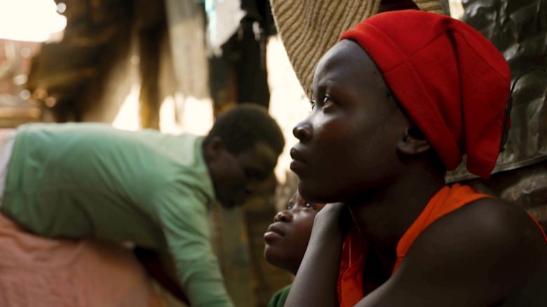 Alice Shikuku (right) sits outside her home in Korogocho with her two daughters.