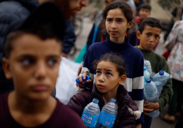 A Palestinian girl holds empty bottles as she queues to collect water in Rafah, southern Gaza, on December 5.