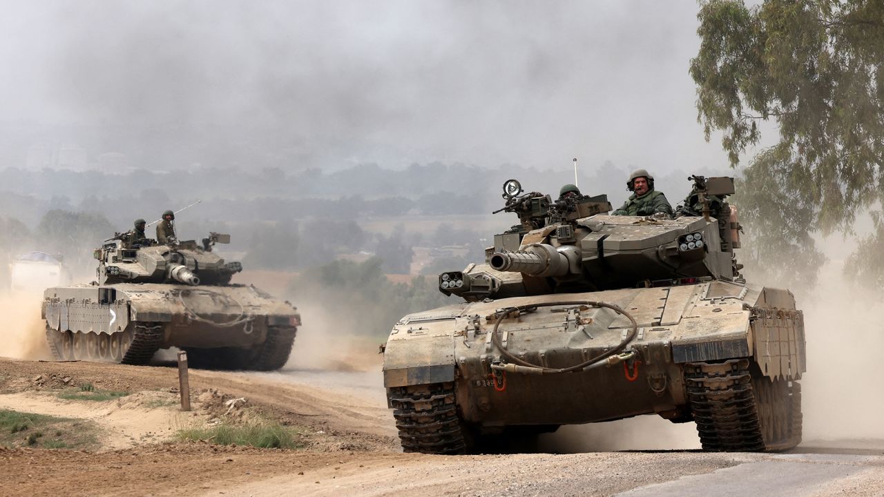 Israeli military tanks roll near the border with the Gaza Strip on December 5, 2023, amid continuing battles between Israel and the militant group Hamas. Israel pressed on with its expanded ground operation against Hamas in the Gaza Strip, following the expiry of a seven-day truce on Friday, after which fighting resumed. Hamas militants from Gaza launched an unprecedented attack on southern Israel on October 7, killing about 1,200 people, mostly civilians, and taking around 240 hostages, according to Israeli officials. (Photo by Menahem KAHANA / AFP) (Photo by MENAHEM KAHANA/AFP via Getty Images)
