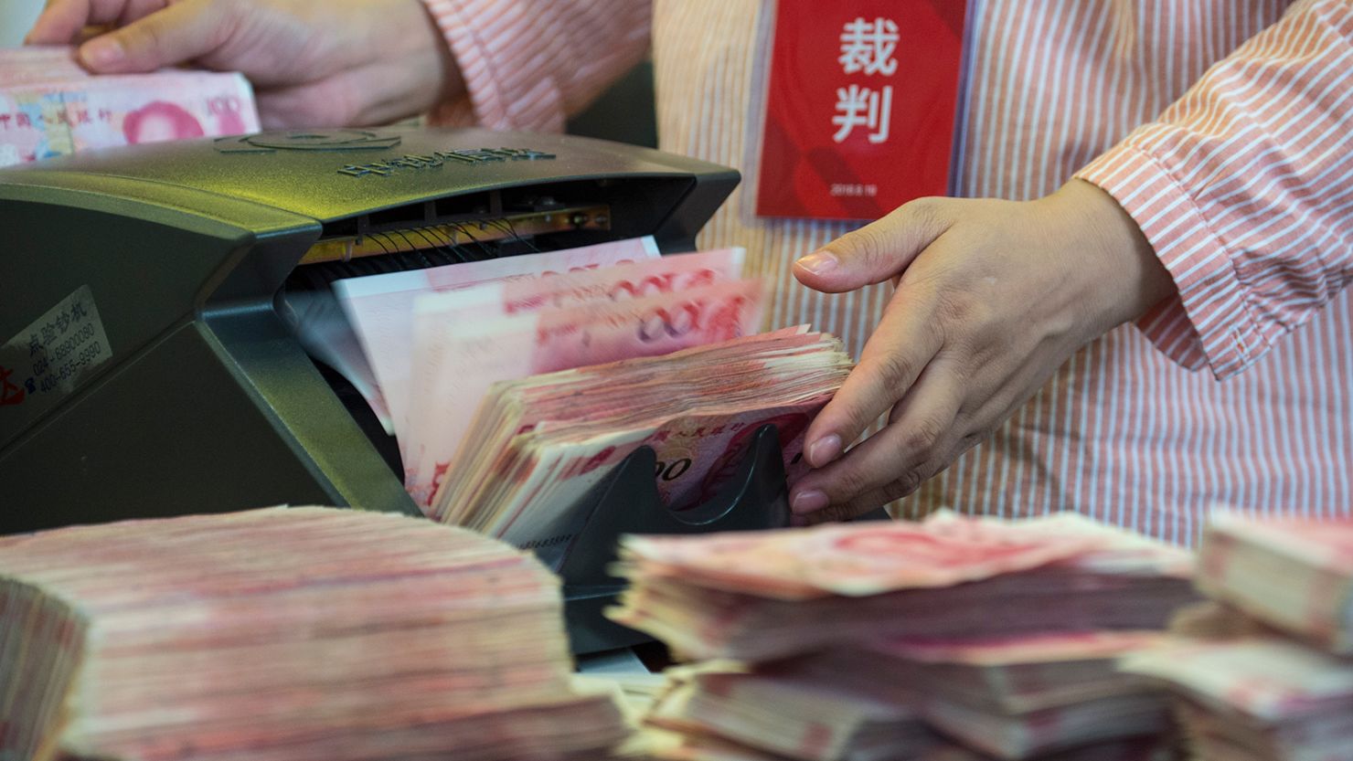 A bank clerk counts RMB (renminbi) yuan banknotes during a money-counting skills contest in Nantong city, east China's Jiangsu province.