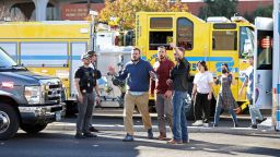 TOPSHOT - Law enforcement escort people outside the University of Nevada, Las Vegas, campus following a shooting in Las Vegas on December 6, 2023. "Multiple victims" were reported in a shooting at a US university on December 6, 2023, with police saying a short time later the suspect was dead. Students and members of the public had been told to avoid the area after reports of an active shooter on the campus of the University of Nevada Las Vegas. (Photo by Ronda Churchill / AFP) (Photo by RONDA CHURCHILL/AFP via Getty Images)
