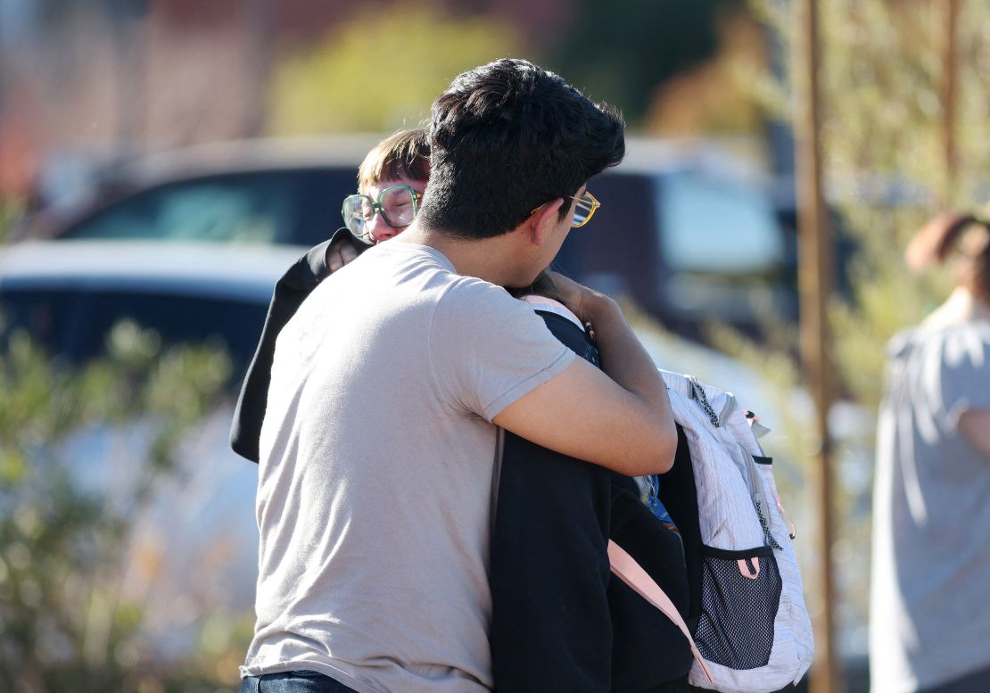 Student Amanda Perez, 23, is comforted by fiance Alejandro Barron, 24, following a shooting at the University of Nevada, Las Vegas, campus in Las Vegas on December 6, 2023. "Multiple victims" were reported in a shooting at a US university on December 6, 2023, with police saying a short time later the suspect was dead. Students and members of the public had been told to avoid the area after reports of an active shooter on the campus of the University of Nevada Las Vegas. (Photo by Ronda Churchill / AFP) (Photo by RONDA CHURCHILL/AFP via Getty Images)