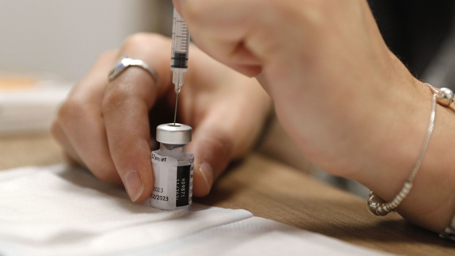 An employee prepares a dose of Comirnaty Omicron XBB 1.5 Pfizer vaccine for COVID-19 at a pharmacy in Ajaccio, on October 5, 2023, during a new COVID-19 vaccination campagin on the French Mediterranean island of Corsica. (Photo by Pascal POCHARD-CASABIANCA / AFP) (Photo by PASCAL POCHARD-CASABIANCA/AFP via Getty Images)