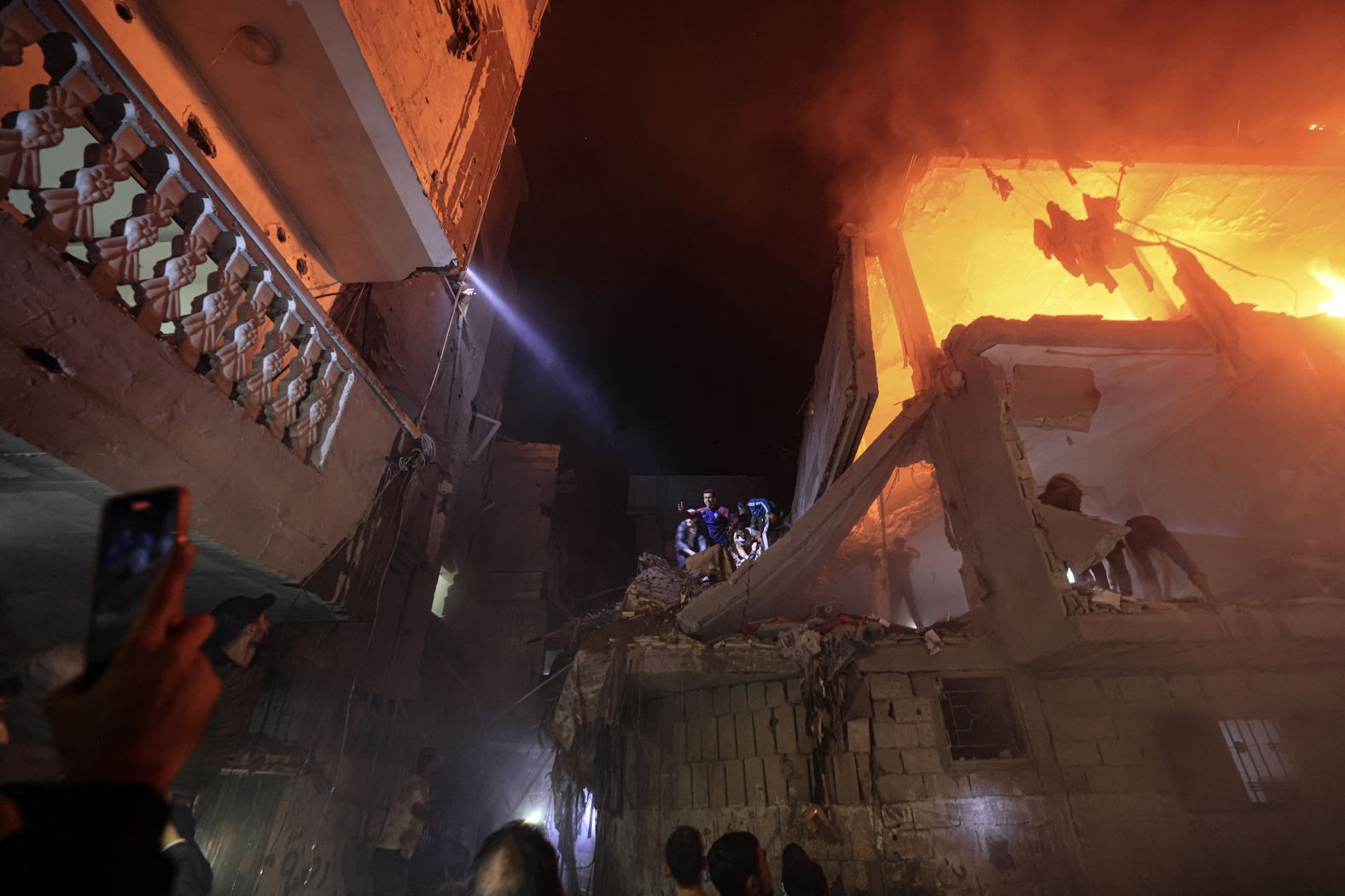 People search for victims amid the rubble of a smoldering building, following an Israeli strike in Rafah, southern Gaza, on Wednesday, December 6.