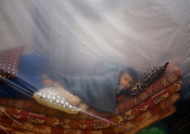 A child sleeps in a makeshift shelter in a new camp sheltering displaced Palestinians who fled their houses due to Israeli strikes, in Rafah, southern Gaza, on December 5.