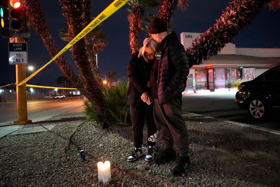 Sean Hathcock, right, kisses Michelle Ashley after the two left candles for victims of a shooting at the University of Nevada, Las Vegas, Wednesday, December 6, 2023, in Las Vegas.