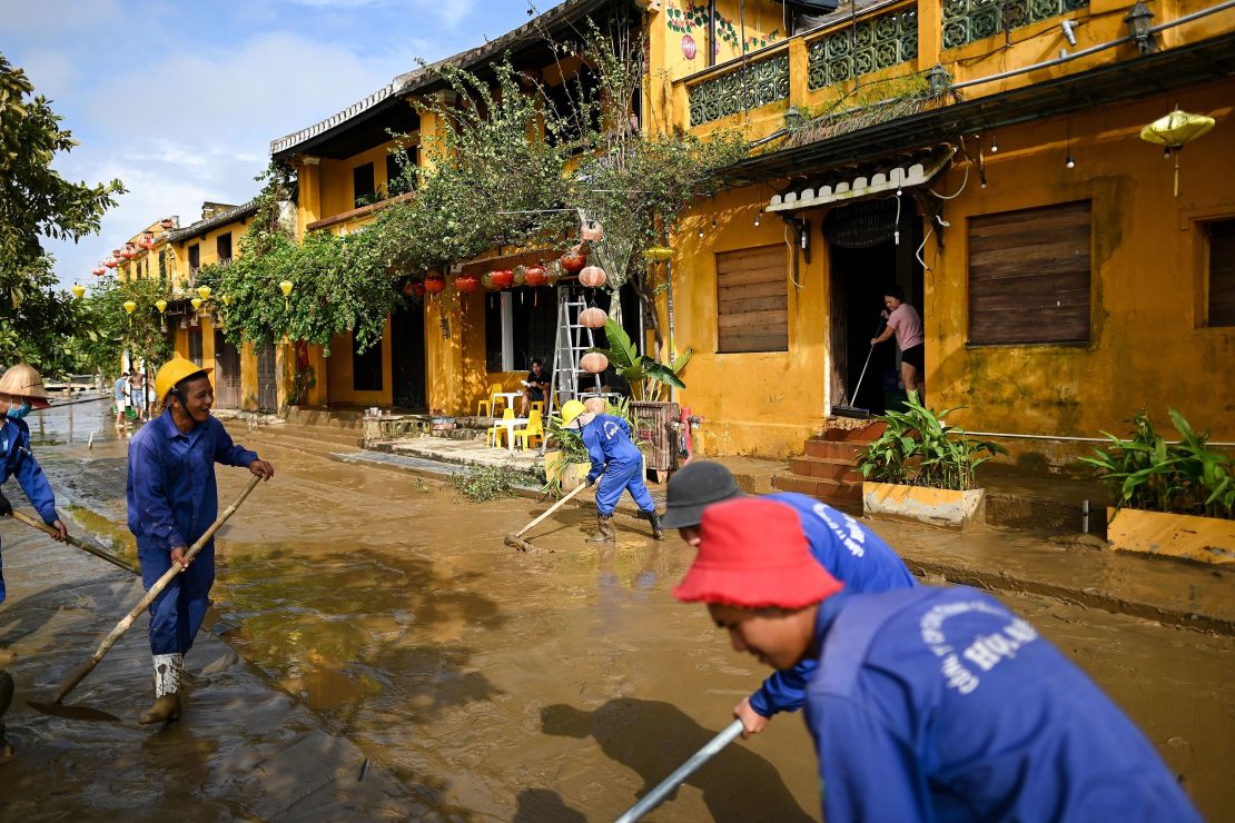 Municipal workers and residents clean up the streets after waters receded in the old city of Hoi An, a UNESCO world heritage site, on October 30, 2020, in the aftermath of Typhoon Molave.
