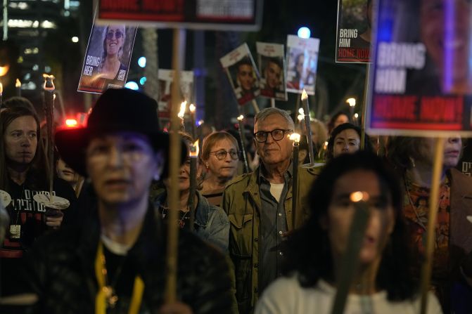 Relatives and friends of hostages held in Gaza by the Hamas militant group light torches and march as they call for their release during the Jewish holiday of Hanukkah in the Hostages Square at the Museum of Art in Tel Aviv, Israel, on December 7.