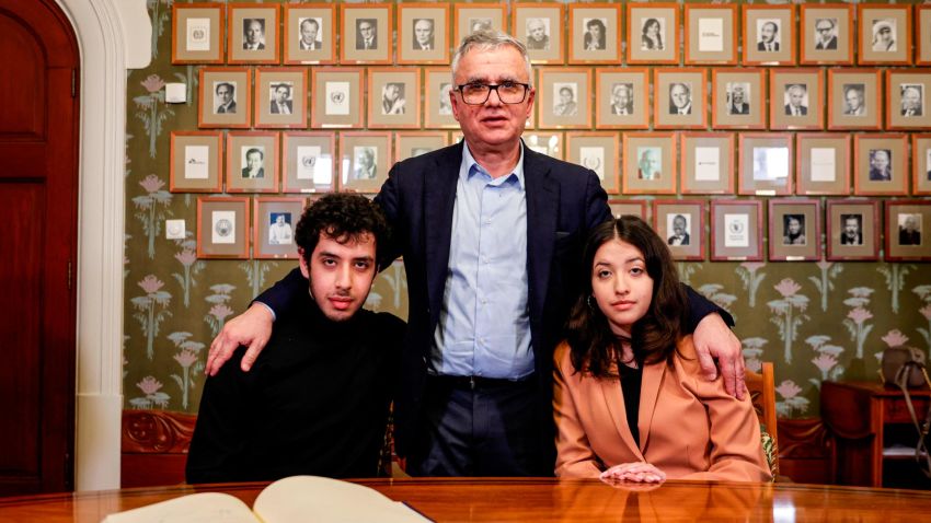 Iranian journalist Taghi Rahmani (C), husband of this year's winner of the Nobel Peace Prize, Iranian human rights activist Narges Mohammadi (not in picture), and their children Ali Rahmani (L) and Kiana Rahmani (R) pose for a picture after signing the guest book at the Nobel Institute in Oslo, Norway, on December 9, 2023.